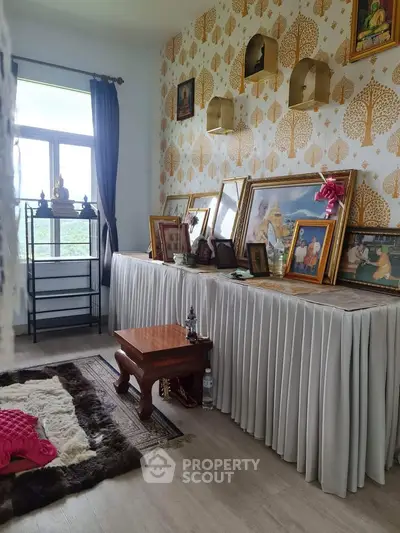 Charming interior room with elegant decor and framed art, featuring a cozy seating area and natural light.