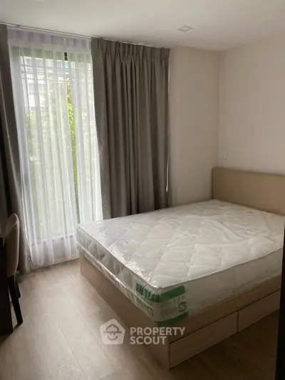 Cozy bedroom with large window and modern furnishings, perfect for relaxation and comfort.