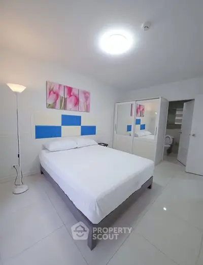 Modern bedroom with white decor and mirrored wardrobe