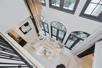 Luxurious high-ceiling living room with elegant chandelier and large windows