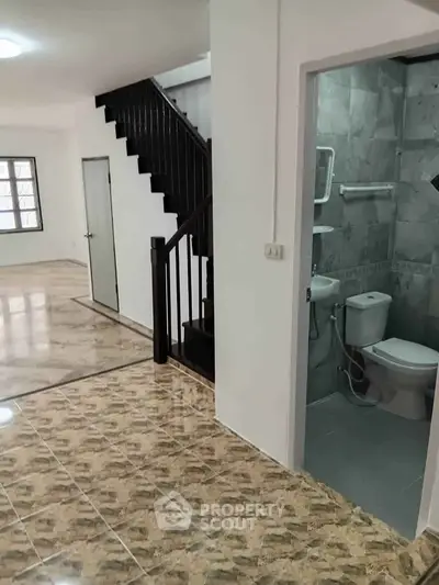 Spacious interior with modern staircase and tiled bathroom in a stylish home.