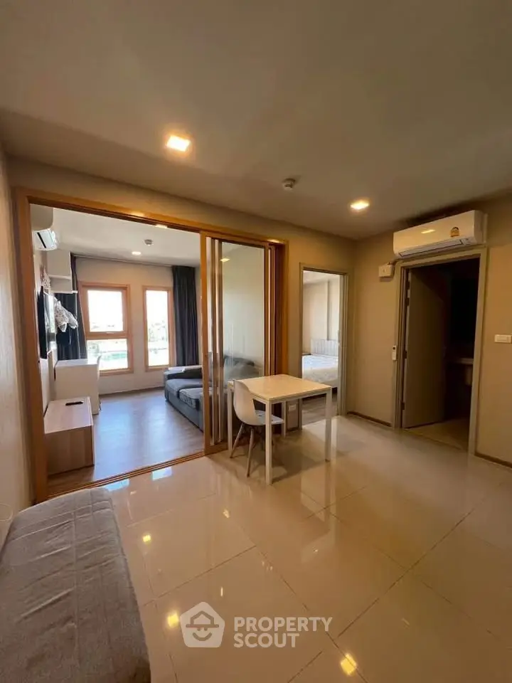 Modern apartment interior with open living and dining area, featuring sleek design and natural light.