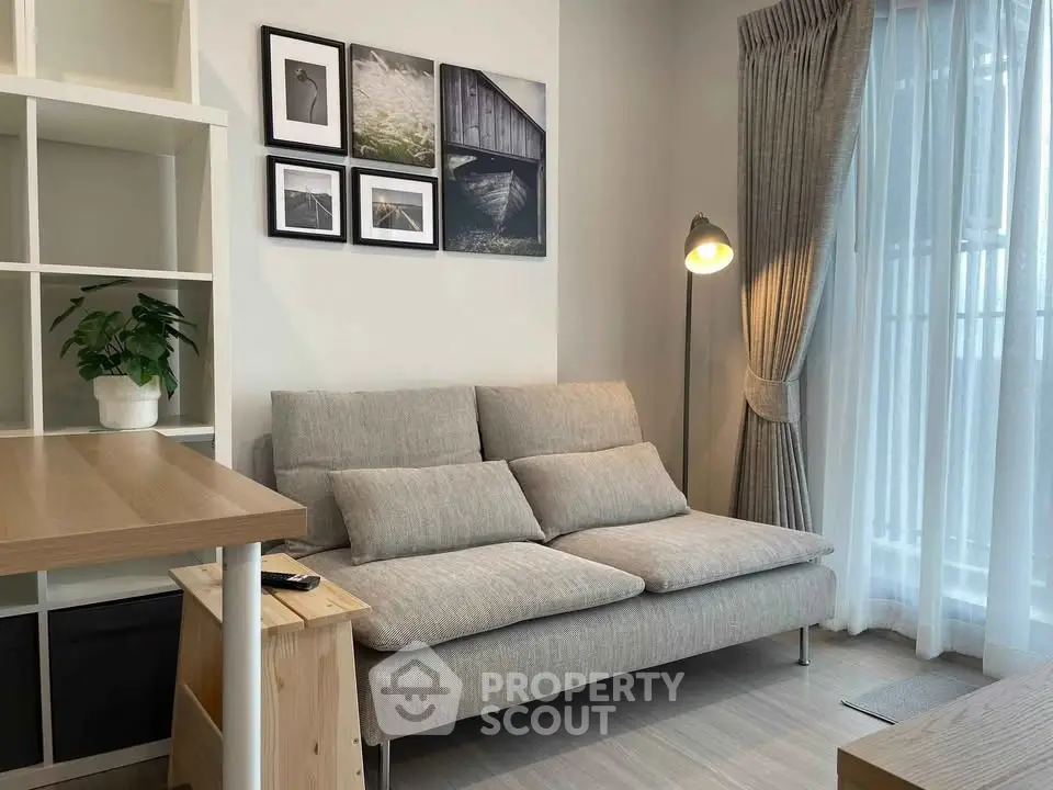 Modern living room with stylish decor and natural light, featuring a cozy sofa and elegant floor lamp.