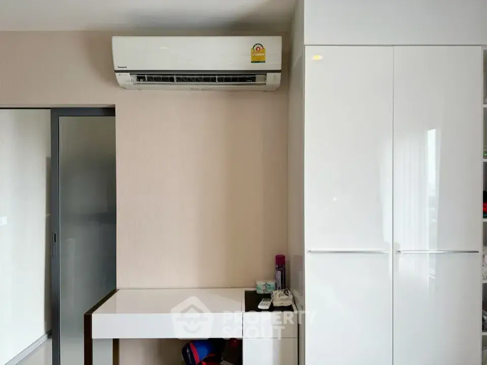 Modern interior with sleek white furniture and air conditioning unit, perfect for a comfortable living space.