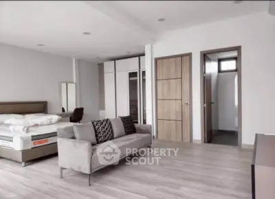 Spacious modern bedroom with elegant decor and ample natural light