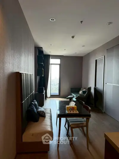 Modern living room with city view, stylish furniture, and natural light.