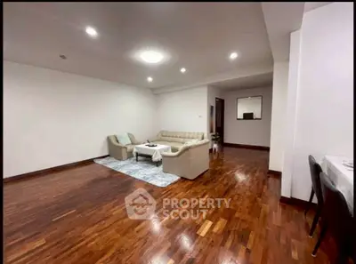 Spacious living room with elegant wooden flooring and cozy seating area.