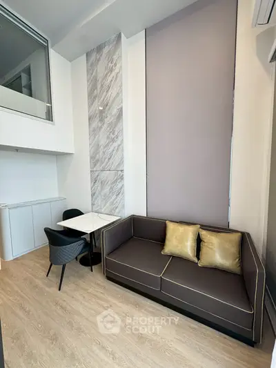 Modern living room with stylish sofa and marble accent wall