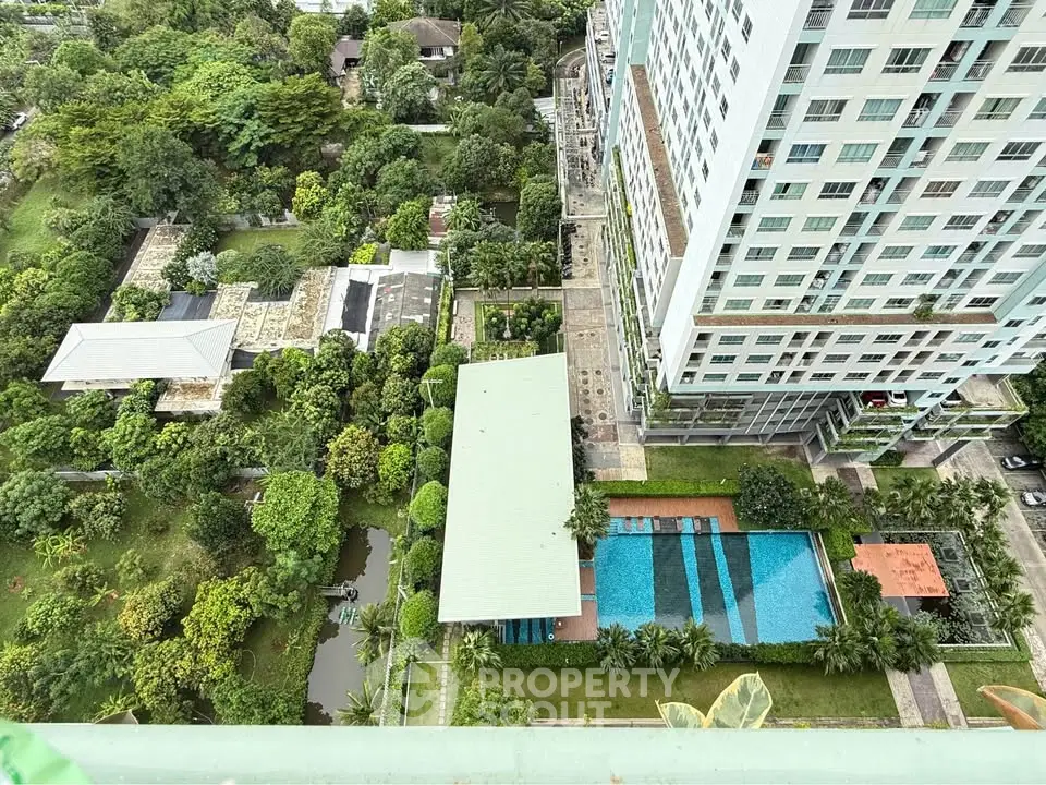 Stunning aerial view of modern high-rise building with lush gardens and inviting pool area.