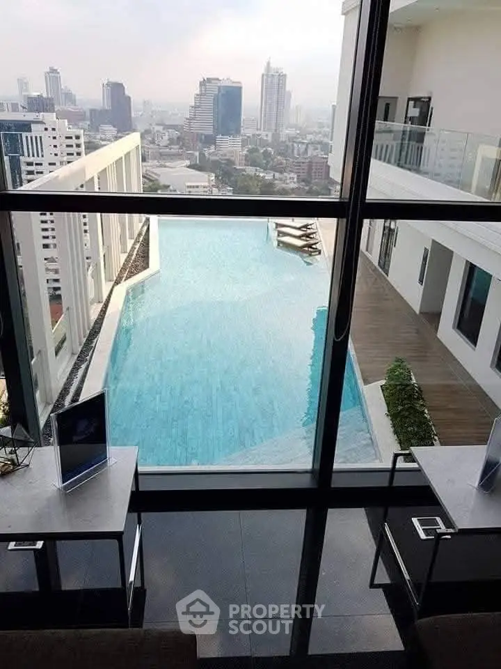 Luxurious rooftop pool with stunning city skyline view from modern high-rise building.