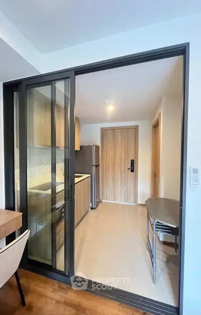 Modern kitchen with sliding glass doors and sleek appliances in a stylish apartment.