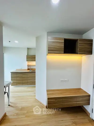 Modern kitchen with sleek wooden cabinets and ambient lighting, perfect for contemporary living.