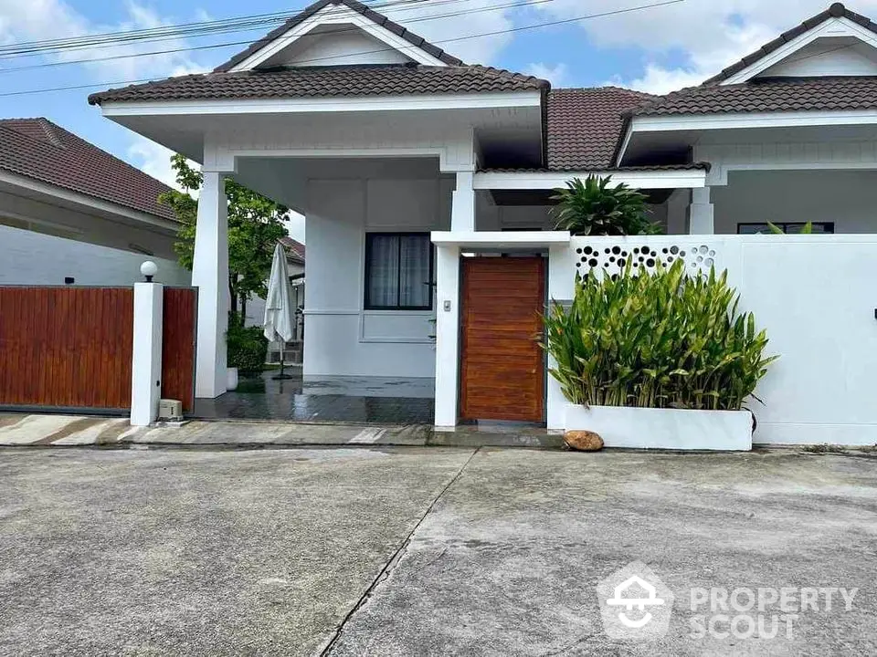 Charming single-story house with modern design and lush greenery in a serene neighborhood.