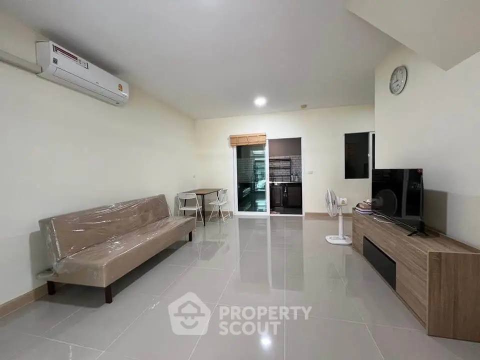 Spacious modern living room with sleek furniture and open kitchen layout