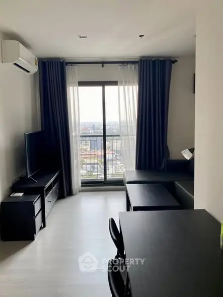 Modern living room with city view, featuring sleek furniture and large window for natural light.