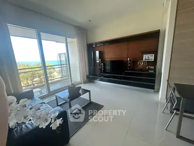 Modern living room with ocean view, sleek furniture, and large windows in a luxury apartment.