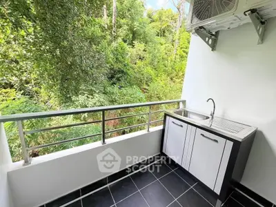 Charming balcony with lush green view and outdoor sink, perfect for relaxation.