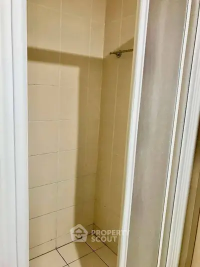 Compact shower area with tiled walls and sliding door