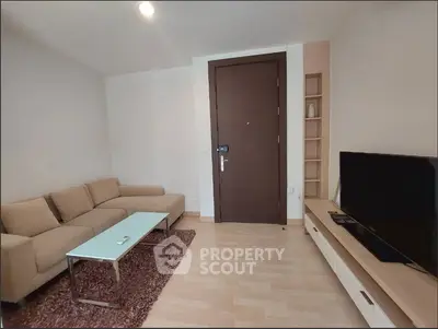 Modern living room with cozy sofa and flat-screen TV, perfect for relaxation.