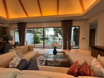 Luxurious living room with pool view, elegant decor, and spacious seating area in a modern home.