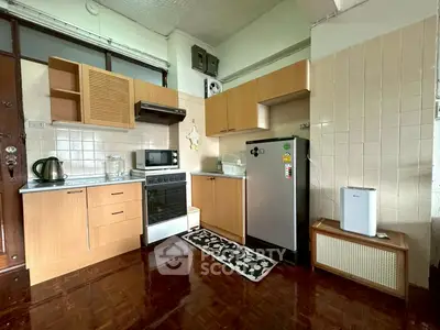 Charming kitchen with wooden cabinets and modern appliances in cozy apartment.