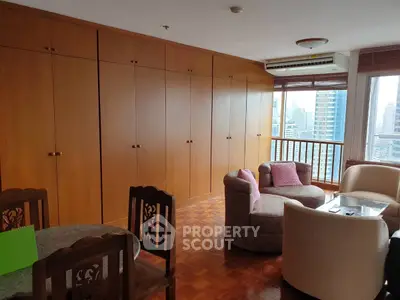 Spacious living room with wooden cabinets and city view