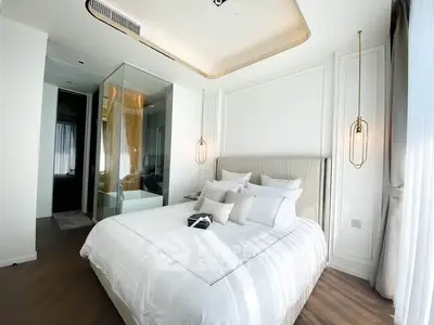 Luxurious modern bedroom with elegant lighting and glass-enclosed bathroom.