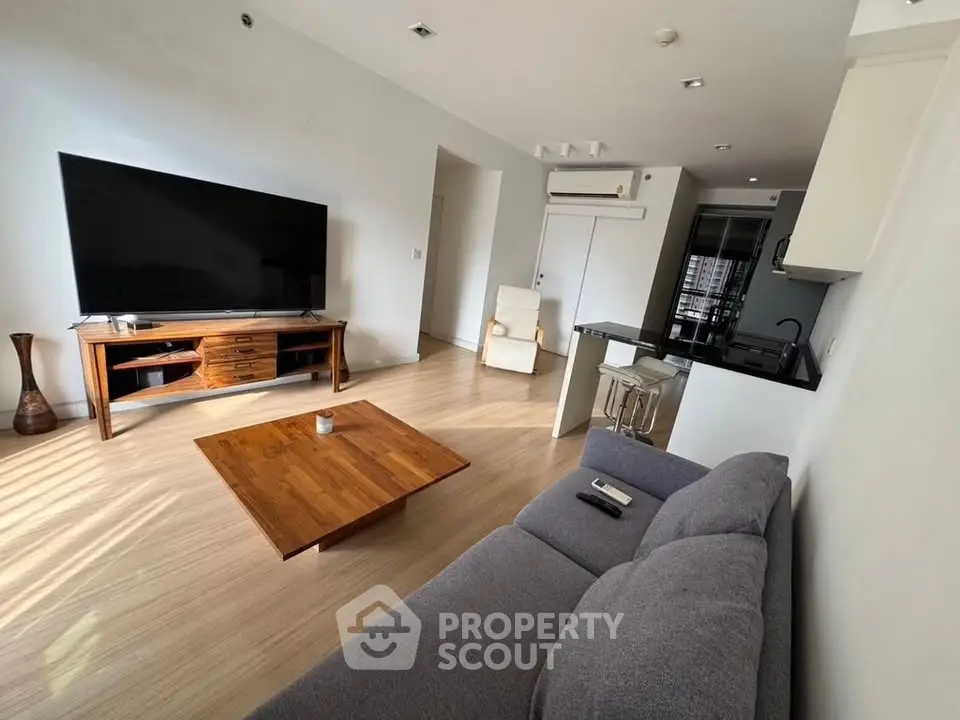 Spacious modern living room with large TV and stylish wooden furniture