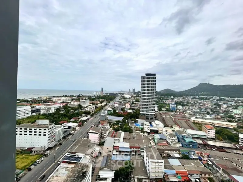 Stunning cityscape view from high-rise building overlooking urban landscape and distant mountains.