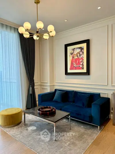 Elegant living room with plush blue sofa and modern chandelier