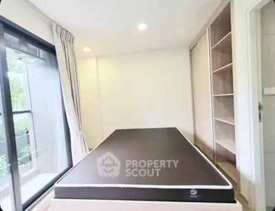 Modern bedroom with large window and built-in wardrobe in a stylish apartment.