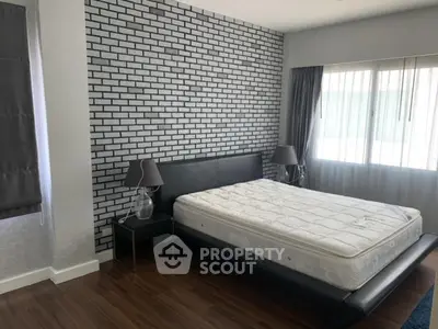 Modern bedroom with stylish brick accent wall and large window