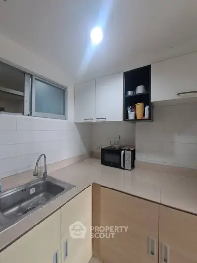 Modern kitchen with sleek countertops and built-in microwave, perfect for culinary enthusiasts.