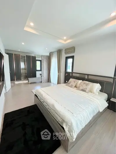 Spacious modern bedroom with elegant decor and ample natural light