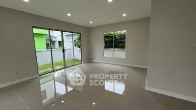 Spacious modern living room with large windows and glossy tiled floors