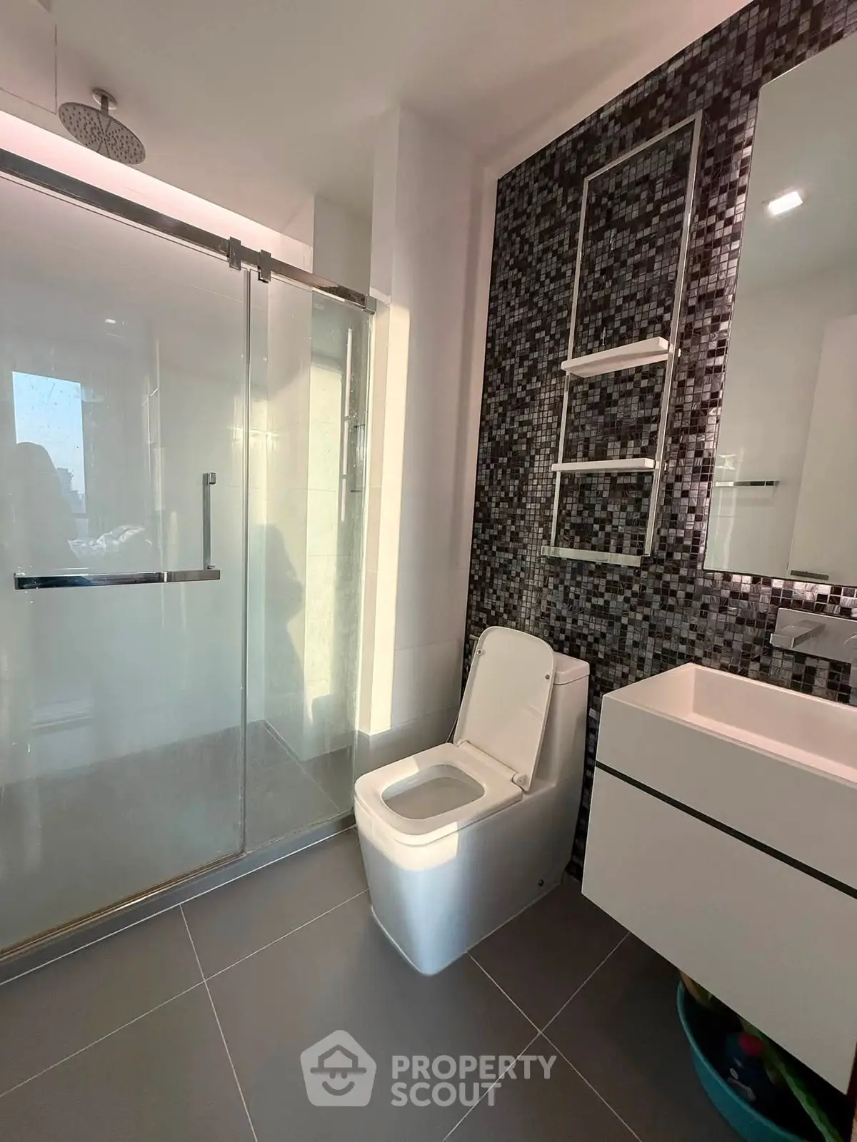 Modern bathroom with sleek shower and stylish mosaic wall tiles.