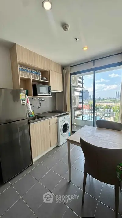 Modern kitchen with appliances and balcony view in urban apartment