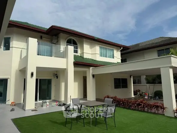 Stunning two-story house with green roof and spacious outdoor patio area.