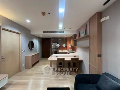 Modern open-layout kitchen and dining area with stylish lighting and wooden accents.