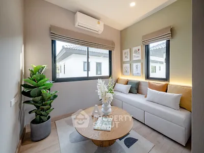 Modern living room with cozy sofa and large windows, featuring stylish decor and natural light.