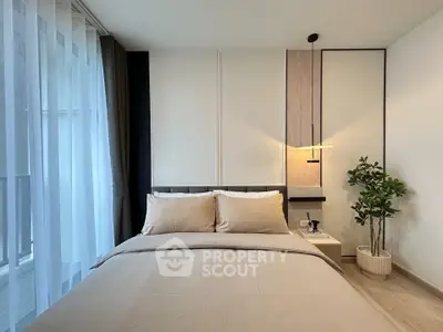 Modern bedroom with elegant decor and natural light, featuring a cozy bed and stylish lighting.