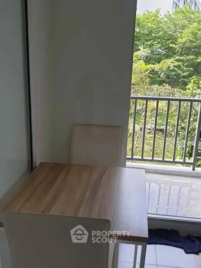 Cozy dining area with natural light and balcony view in modern apartment.