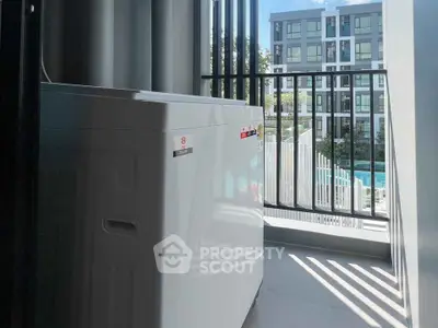Modern apartment balcony with washing machine and pool view