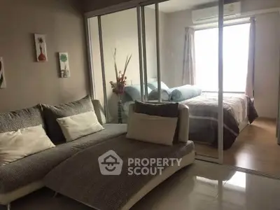 Modern apartment with cozy living room and bedroom separated by glass partition, featuring stylish decor.