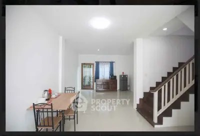 Spacious modern living area with dining table and staircase in bright home