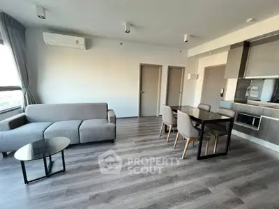 Modern living room with sleek furniture and open dining area in a stylish apartment.