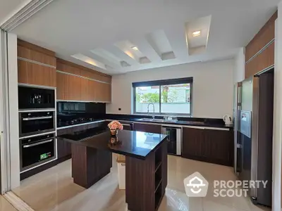 Modern kitchen with sleek design, featuring island and built-in appliances, perfect for culinary enthusiasts.