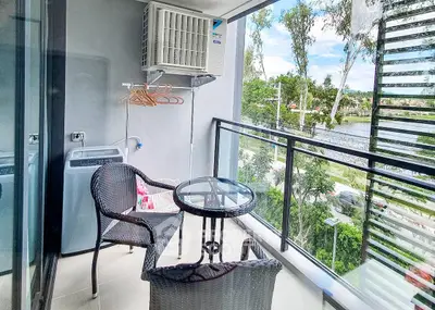 Charming balcony with outdoor seating and lush green view, perfect for relaxation and leisure.