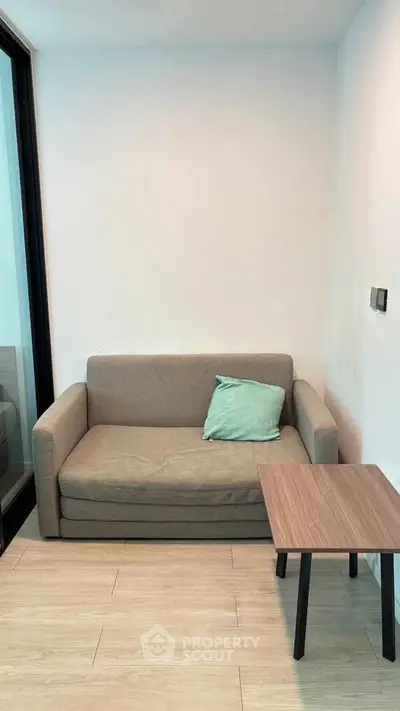 Cozy living room with modern sofa and sleek wooden table, perfect for relaxation and style.