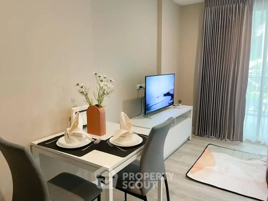 Modern living room with dining area, stylish decor, and natural light from large window.